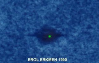 The single surviving photograph attributed to diver Erol Erkmen, said to have been taken at 57 meters in Saros Bay on 15 August 1990. It shows a column of blue water, a dark oblong smudge, and a small intense green point of light at its center. The "disc-shaped object" reported by the witness became visible, by his own account, only after the print was enlarged 300 times; the green light did not appear on the negative at all. The added caption "EROL ERKMEN 1990" is part of the recirculated image, not the original frame.</heroImageCaption>
<parameter name="heroImageCredit">Attributed to Erol Erkmen, 1990; circulated through Sefer Murat Aksoy's "Turkey USO Sightings" and Carl Feindt's waterufo.net database.