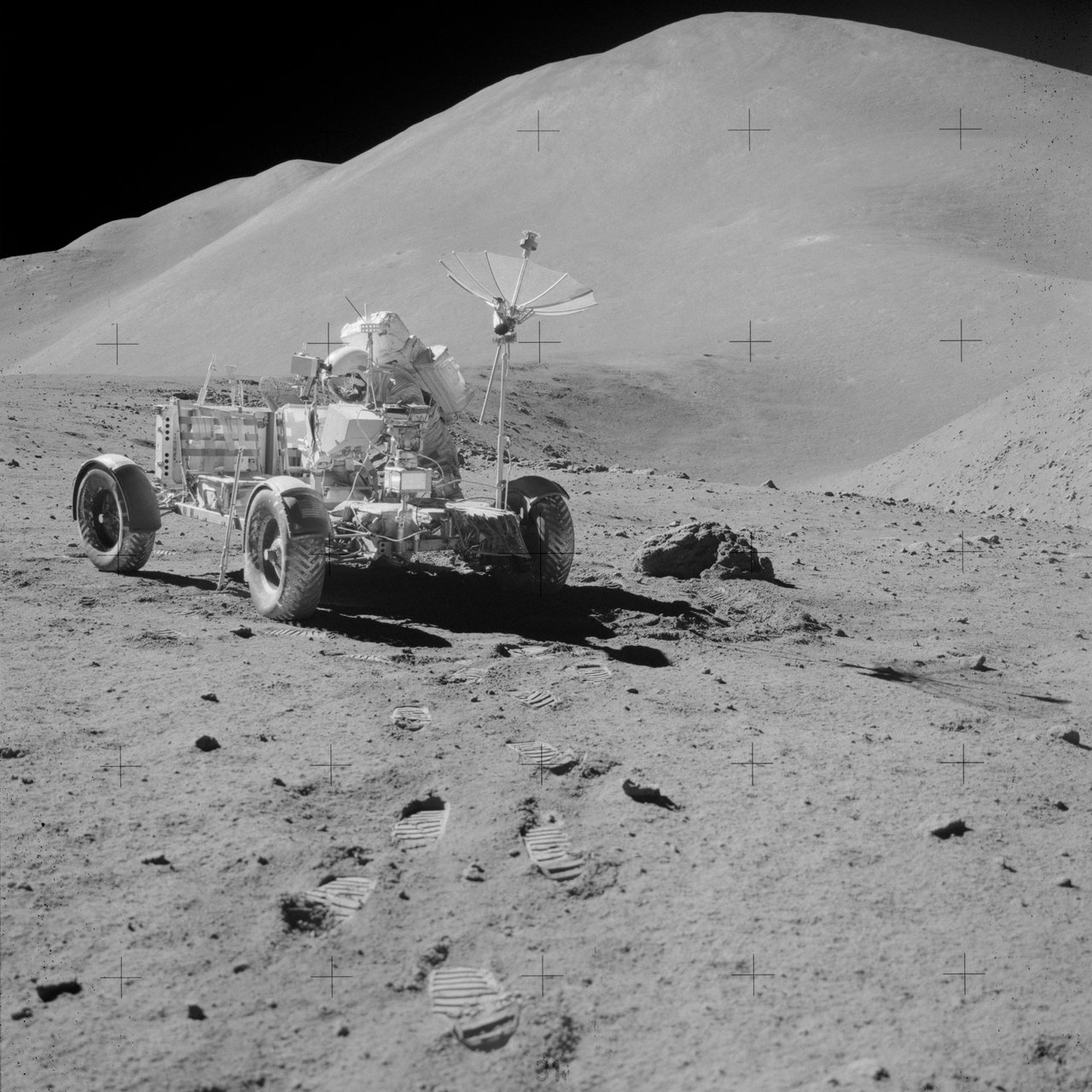 Authentic NASA Apollo 15 Hasselblad photograph AS15-82-11121: astronaut David Scott working at the Lunar Roving Vehicle at Station 9A on the rim of Hadley Rille during the third moonwalk, 2 August 1971, with Hadley Delta, Silver Spur and St. George Crater on the skyline. This is the real location the anonymous witness describes the object circling. It is a documentary mission photo, not an image of any UFO; no photograph of the reported object exists.