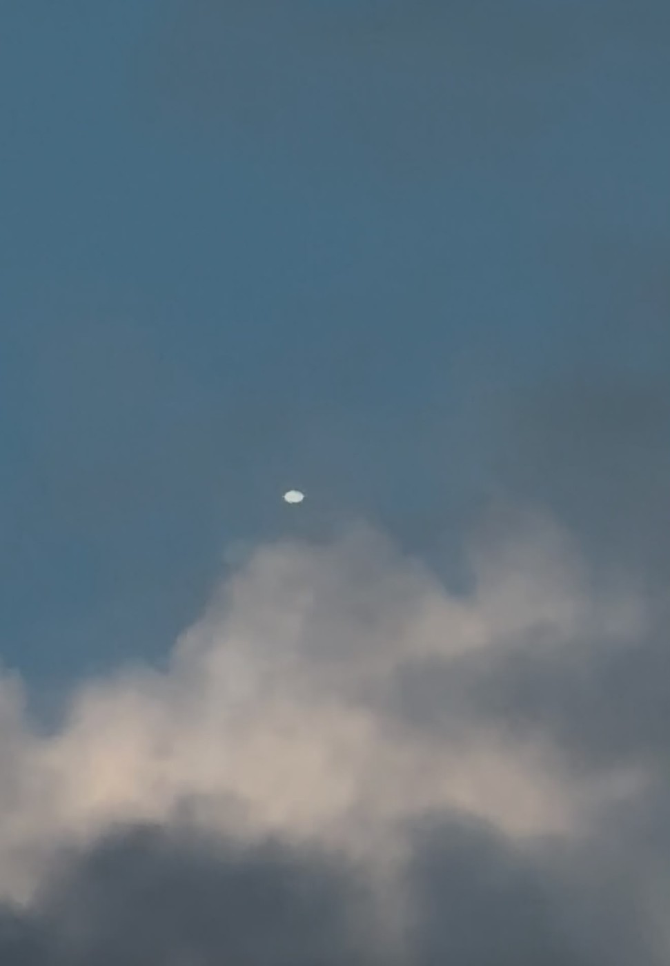 The fifth image filed with the report, showing the object above a substantial cloud. This frame is treated separately from the other four: it has a different aspect ratio, the archive flags it as carrying no camera metadata, and it is the only one showing cloud, while Bishop Airport reported a clear sky at both the 18:56 and 19:56 observations. Its provenance is unestablished and no conclusion in this case file rests on it.
