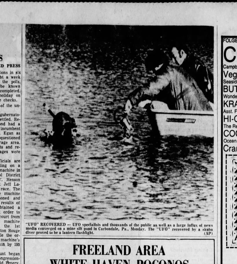 Contemporaneous Associated Press wire photograph published in newspapers in November 1974, showing the scuba diver in a rowboat at the Carbondale mine-silt pond during the recovery operation. The original newspaper caption reads: "'UFO' RECOVERED. UFO specialists and thousands of the public as well as a large influx of news media converged on a mine silt pond in Carbondale, Pa., Monday. The 'UFO' recovered by a skuba diver proved to be a lantern flashlight. (AP)." This is a genuine period news photo, not a recreation or render.