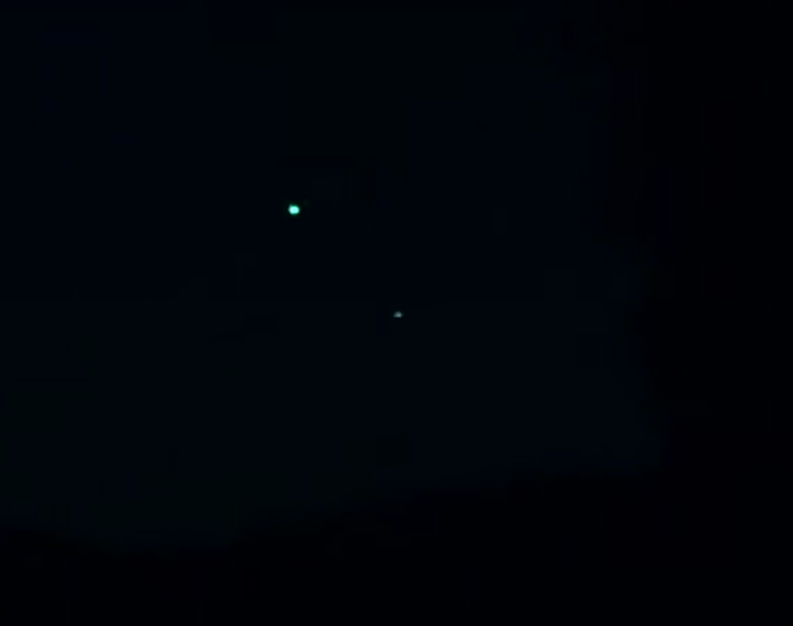 Enlarged crop at 51 seconds showing two separate sources at different brightness. The witness reported five lights in total over about thirty minutes, with individual lights fading for roughly a minute before brightening again.