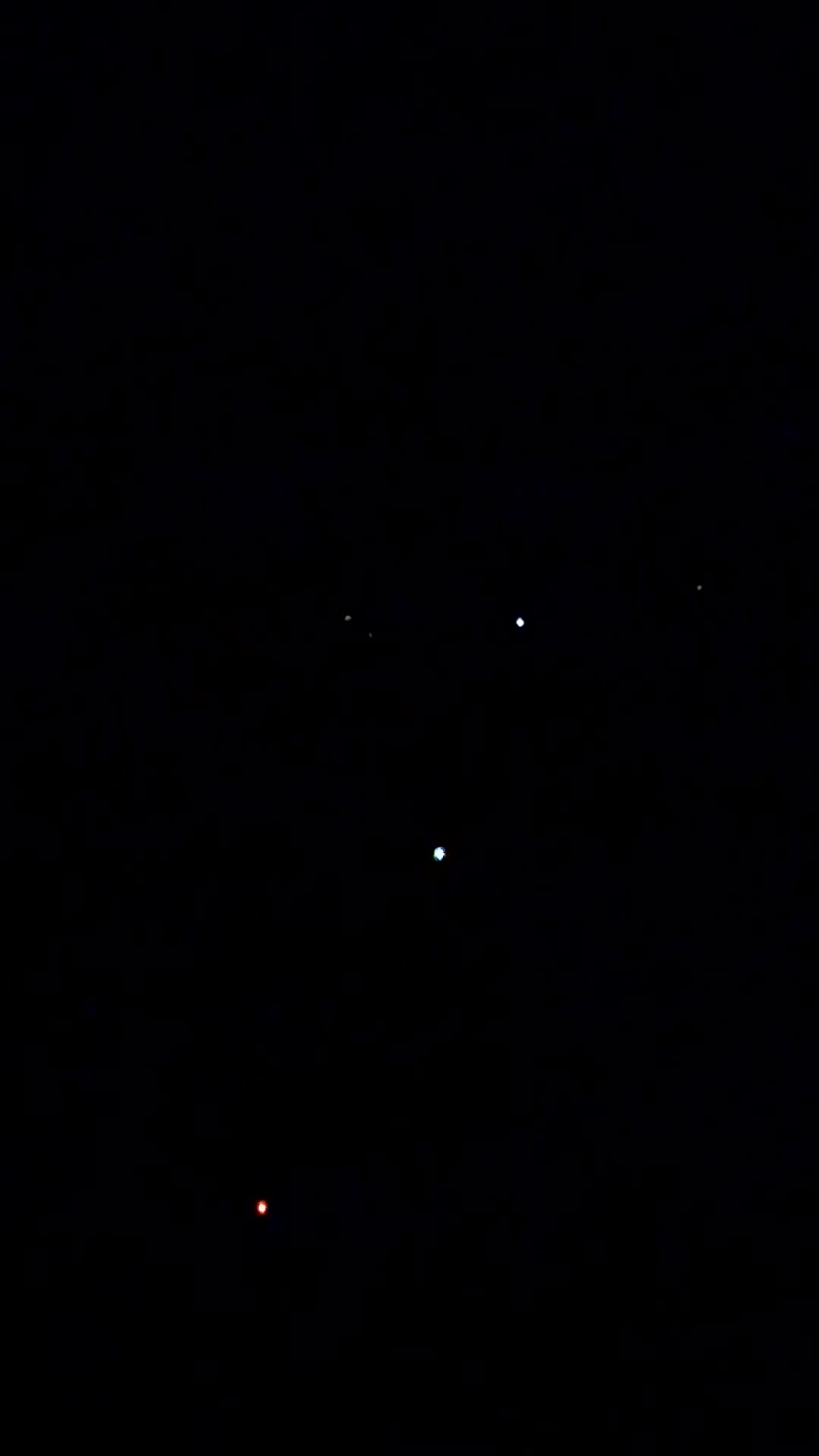 The same footage at twenty seconds, brightened identically. The sources remain unresolved points; across the whole clip the brightest holds a steady peak near 210 of 255 with no fade to extinction, which is not what a satellite losing sunlight does.