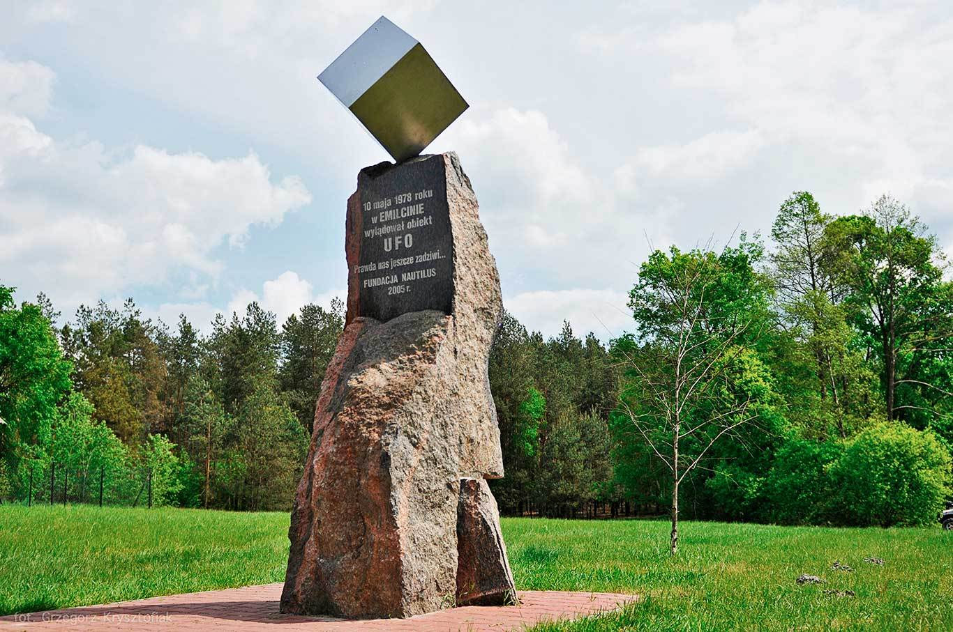 This is a photograph of the Emilcin UFO monument, not of the reported event. No imagery of the 10 May 1978 encounter exists. The monument was unveiled on 15 October 2005 by Fundacja Nautilus, from a concept by the Polish painter Andrzej Fogtt, and stands in the village of Emilcin rather than at the exact clearing Jan Wolski described, so that visitors can reach it. It is a polished metal cube balanced on a rough granite plinth, a deliberate nod to the monolith in Kubrick's 2001. The inscription, read directly off this photograph, runs: 10 maja 1978 roku w EMILCINIE wyladowal obiekt UFO, then Prawda nas jeszcze zadziwi followed by three trailing dots, then FUNDACJA NAUTILUS 2005 r. In English: on 10 May 1978 a UFO object landed in Emilcin. The truth will yet astonish us.