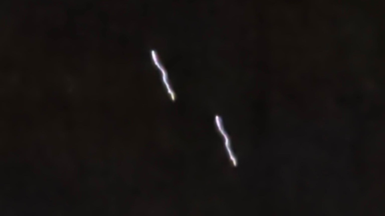 One of the two frames published by the Hereford Times, showing a pair of wavy light trails against an otherwise black sky. The two trails are the same curve, offset. Measured against each other they superimpose at an intersection over union of 0.71 under pure translation, with no rotation or rescaling applied.