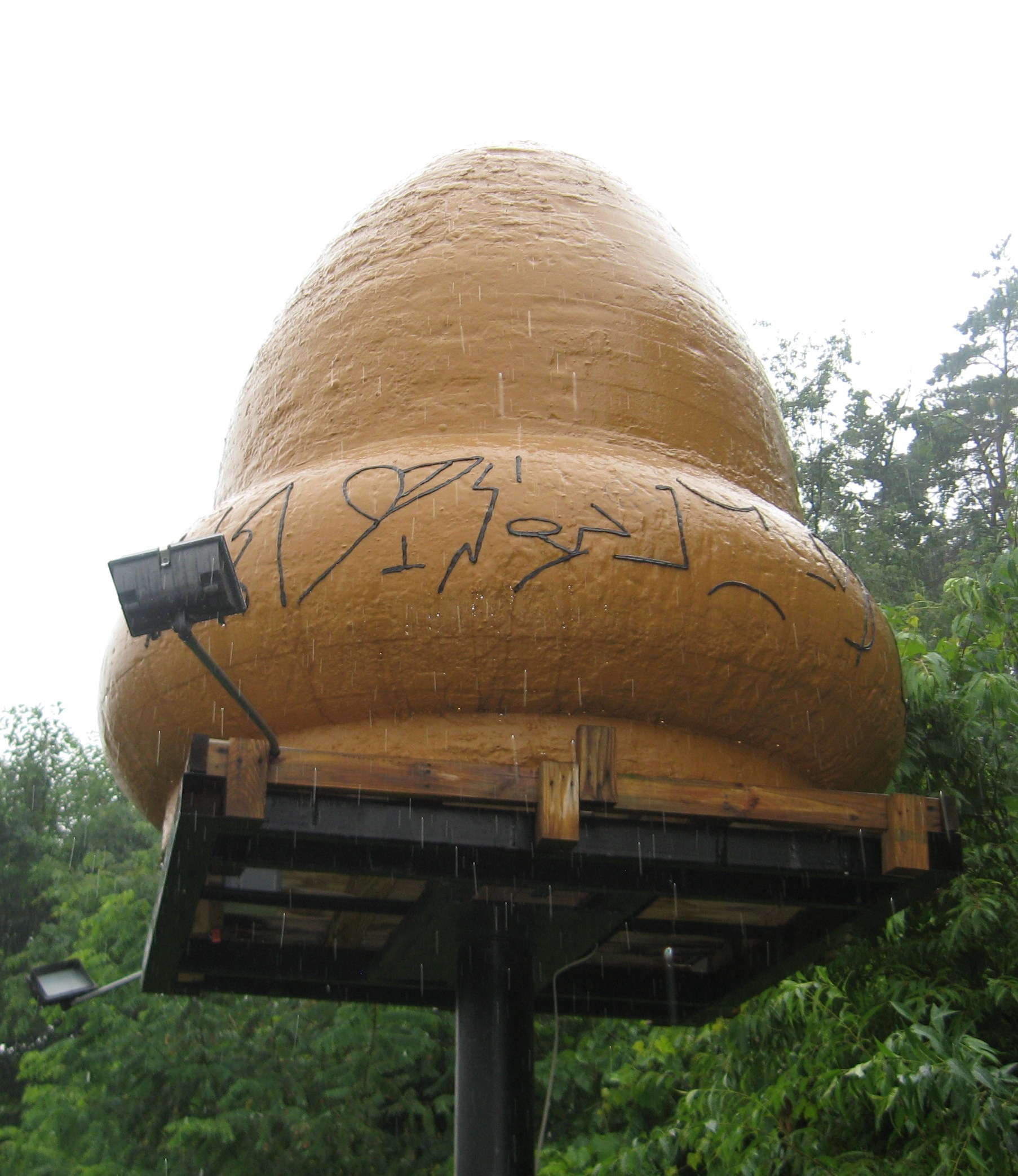 The full-size acorn-shaped replica that stands at the Kecksburg Volunteer Fire Department. It was built from eyewitness descriptions, including James Romansky's, for a 1990 episode of Unsolved Mysteries and left in the village, where it now sits on a raised pole behind the fire station. The band of raised symbols around its base reproduces the "hieroglyphic" markings witnesses said they saw on the object.