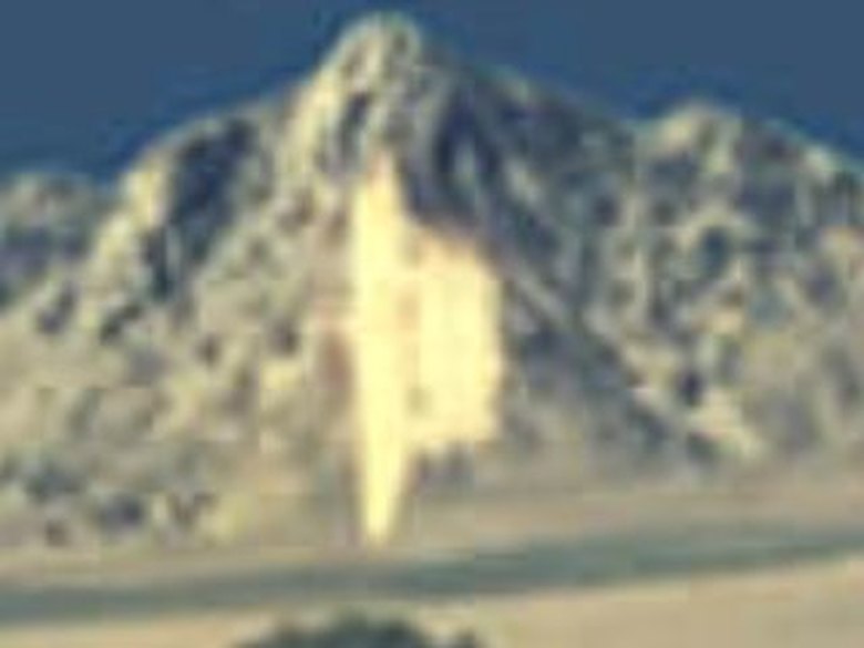 The 1957 Lake Isabella color slide, showing a tilted saucer-shaped object glowing above an old oak tree on the dry lakebed. This is a scan of the original photographic slide, not a recreation. The photographer, identified only as "B.C.", did not see the object at the scene and only noticed it after his Kodak slides were developed.