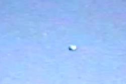 A still frame from the original 1991 eclipse footage as broadcast: the "object" is a small, slightly elongated overexposed blob of white light against a pale washed-out sky. This is the raw video still, not a recreation or render. The appearance is consistent with a 1991 camcorder recording a single very bright point source, the planet Venus, which shone at magnitude -4.8 during totality.