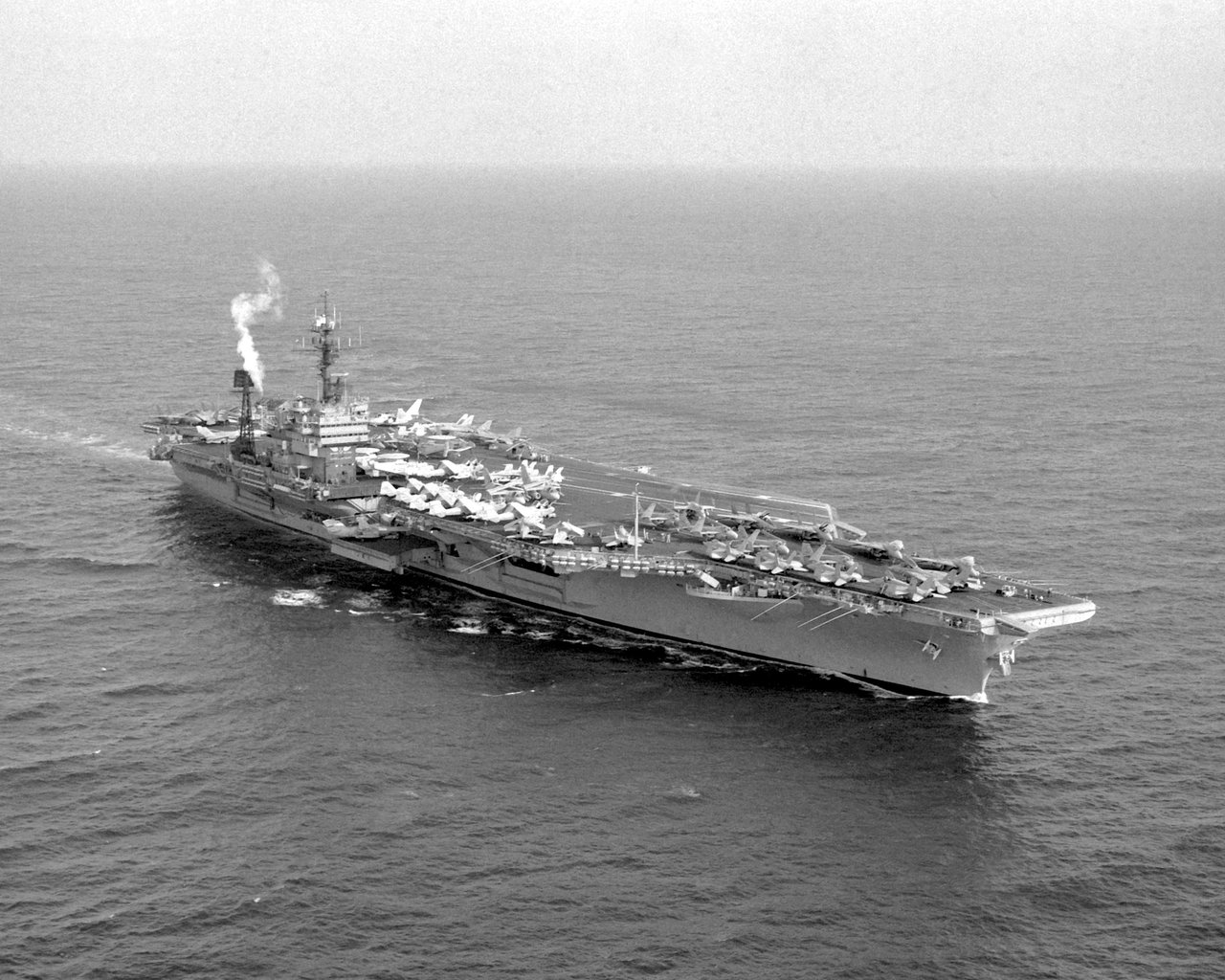 Official US Navy photograph of the aircraft carrier USS John F. Kennedy (CV-67) underway, a starboard bow view. This is a real photograph of the actual ship named in the case, not an image of the reported object. No photograph of the alleged 1971 sphere exists; the encounter is a memory report with no visual record.