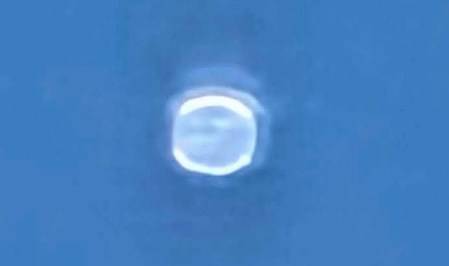 A heavily magnified and overexposed still of the reported object over New Castle, Colorado on 4 August 2026, as circulated by the aggregator accounts. The frame contains no horizon, no landscape and no reference object, so nothing in it establishes the object's size, range or altitude. The rounded square outline with a bright rim and a washed out interior is consistent with a small bright point source photographed out of focus at extreme digital zoom.