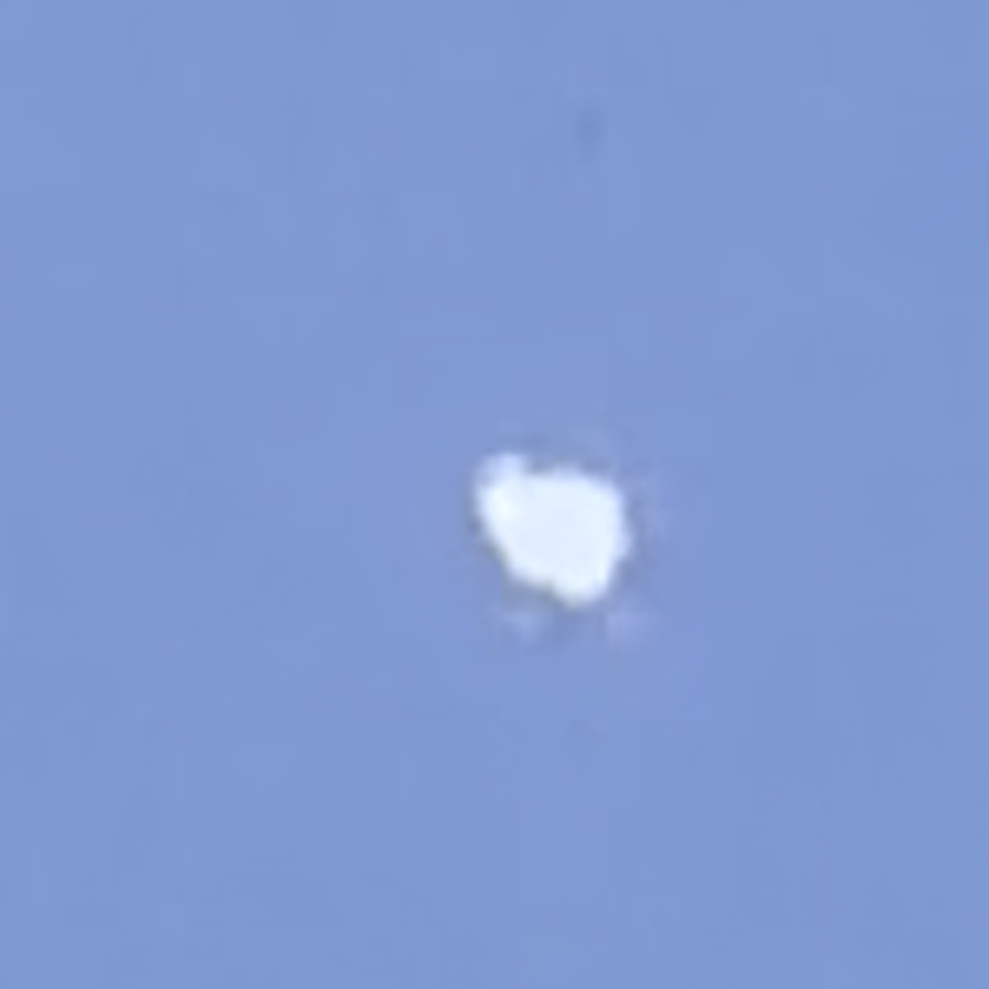 The brightest object enlarged from the longer witness clip. The outline is irregular and lobed rather than a point or a disc, and it changes shape between frames.
