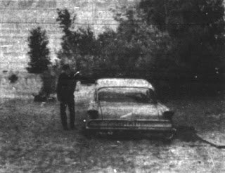 A period photograph of the automobile bogged down in the soft sand at Beach 6, Presque Isle State Park, where the witnesses sat when the lighted object came down on the night of 31 July 1966. This is a documentary photograph of the actual site and car, not a recreation or illustration. The companion images in the same case archive are photographs of the plaster casts that an Air Force officer made of the impressions found in the sand.