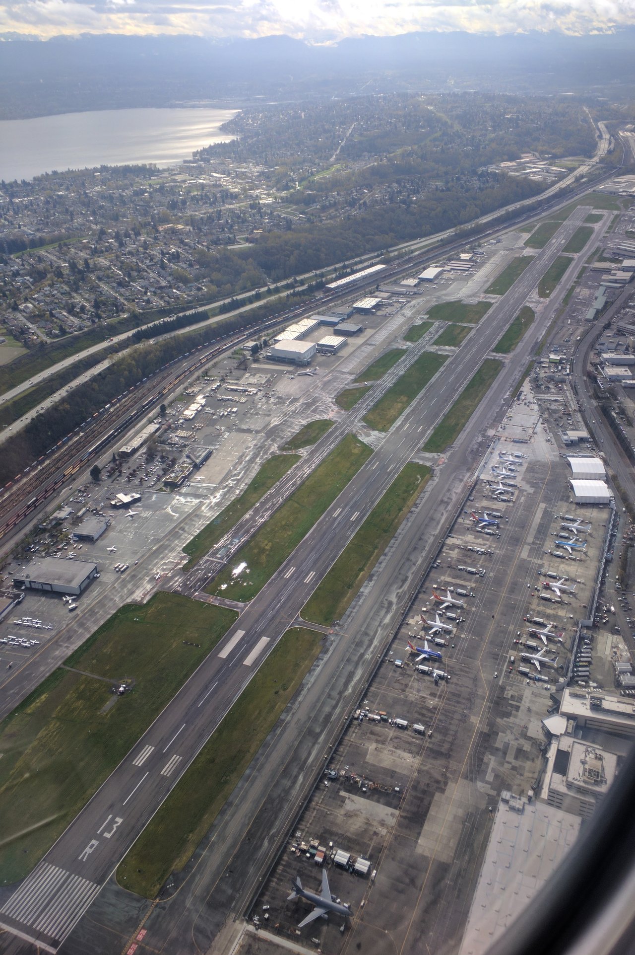A real aerial photograph of King County International Airport (Boeing Field) in Seattle, seen from the northwest, the same airfield over which the black triangle drifted. East Marginal Way South, where Gary Val Tenuta pulled his car over and stepped out to watch the object pass overhead, runs along the western edge of the field shown here. This is a documentary photo of the location, not a depiction of the craft; no photograph of the object exists because the witness had no camera.