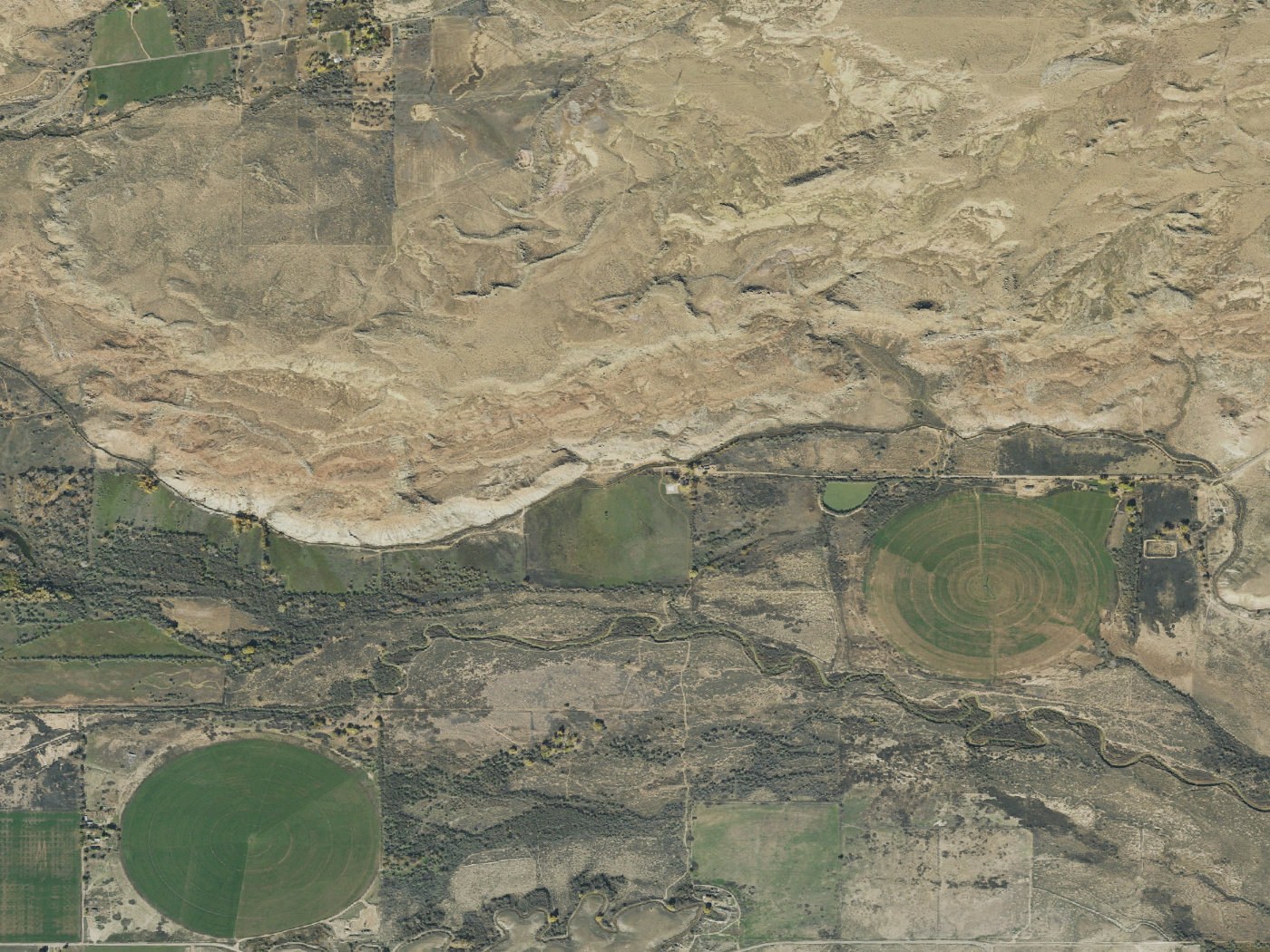 The terrain of the reported location, near Randlett in Uintah County, Utah, in United States Geological Survey aerial imagery centred on the coordinates of the ranch. The rock ridge running across the frame and the creek bottom below it match the isolation described in the Deseret News report of 30 June 1996, which placed the 480 acre property three miles from the main road behind a creek and a ridge. This is terrain context and not evidence of any reported event.