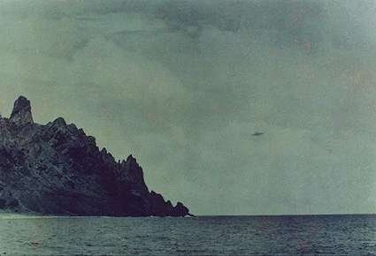 One of the four original photographs taken by Almiro Barauna from the deck of the Brazilian Navy ship NE Almirante Saldanha on 16 January 1958, showing the dark Saturn-shaped object near the coastline of Trindade Island. This is a genuine 1958 photographic frame, not a model or recreation.