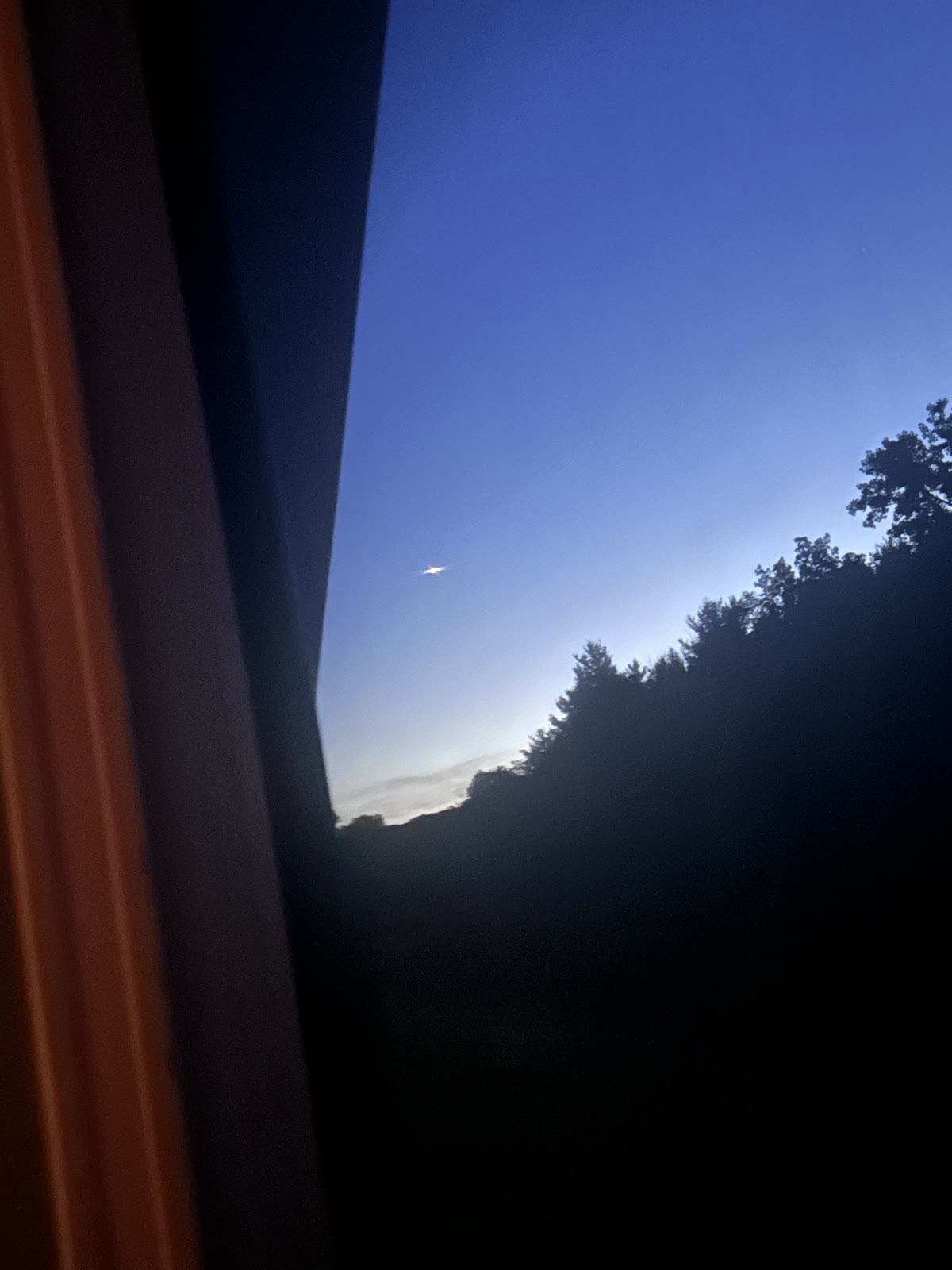 The witness photograph over Western New York, 3 July 2026, the bright source smeared into a single streak by the long handheld night exposure. Witness photograph.