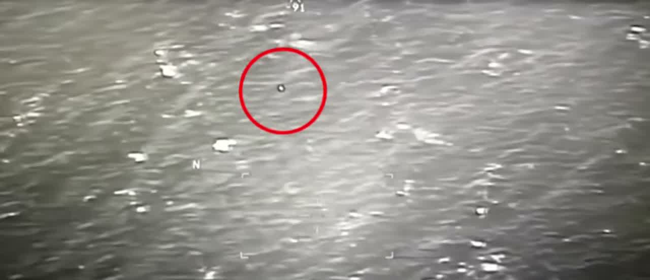 A frame from the whistleblower-provided MQ-9 Reaper targeting footage shown at the 9 September 2025 House Oversight Committee hearing, showing the small dark object tracked over open water off Yemen. The red circle is a broadcaster annotation marking the object.