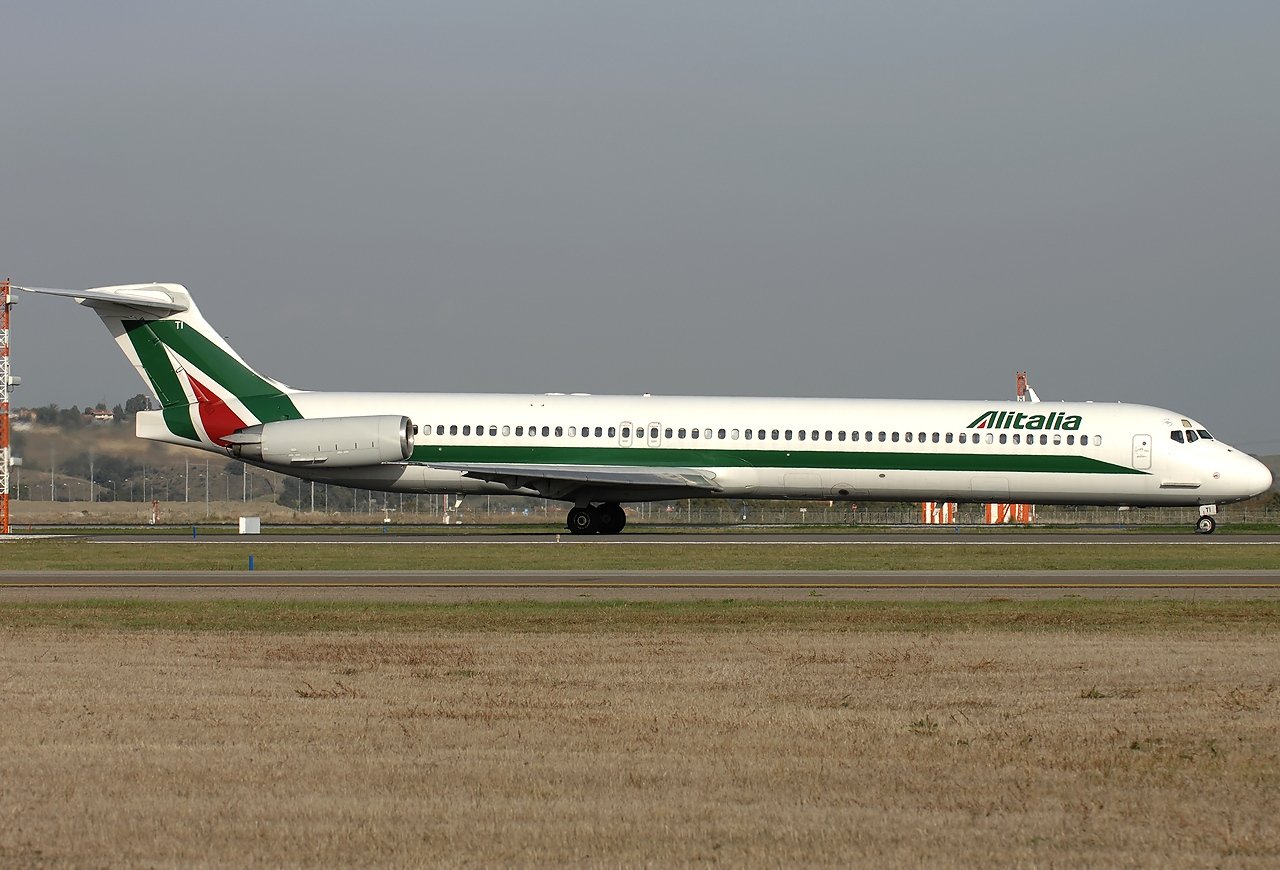 A real photograph of an Alitalia McDonnell Douglas MD-82 in the green, white and red livery of the period, the same aircraft type Captain Zaghetti was flying as Alitalia AZ284 on 21 April 1991. This is a representative aircraft of the type, not the actual incident aircraft, which was the MD-82 registered I-DAWC. No staged recreation or render is used.